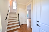 a hallway with white doors and hardwood floors