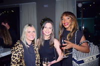 three women posing for a photo at a party