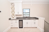 a kitchen with white cabinets and a refrigerator